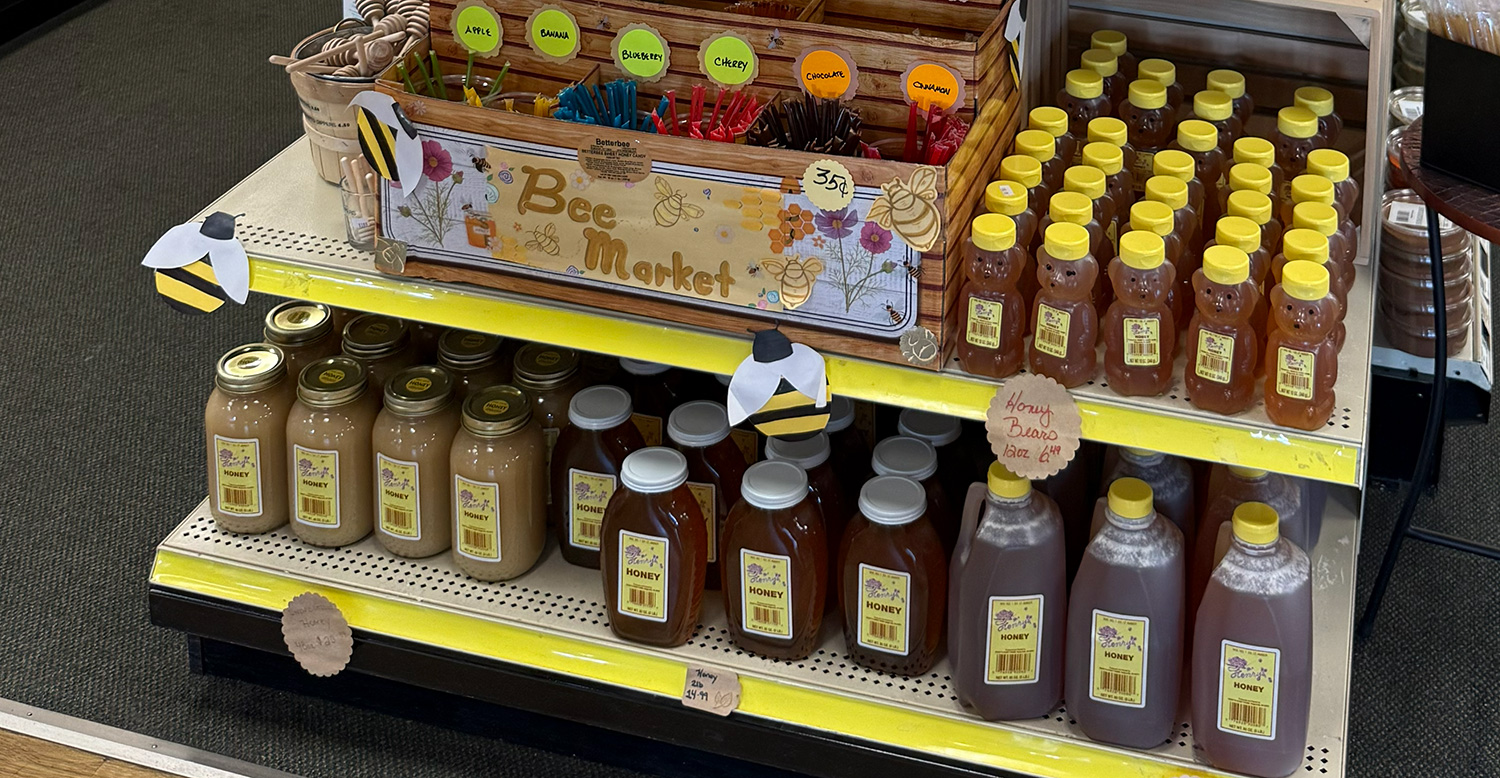 Shelves with jars of honey and flavored honey sticks